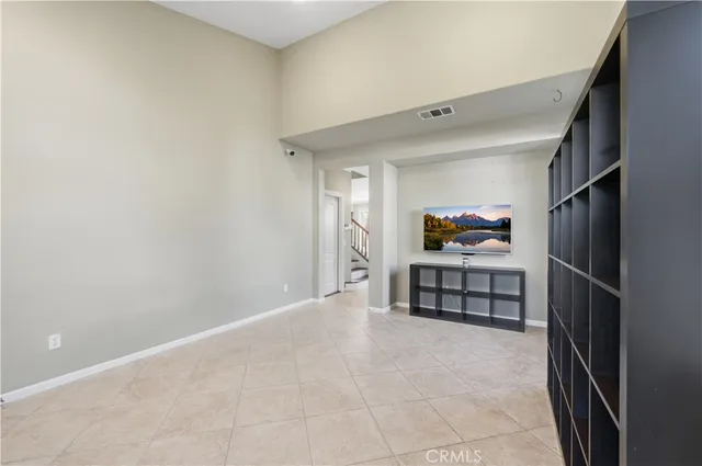 a view of a livingroom with furniture and an empty refrigerator