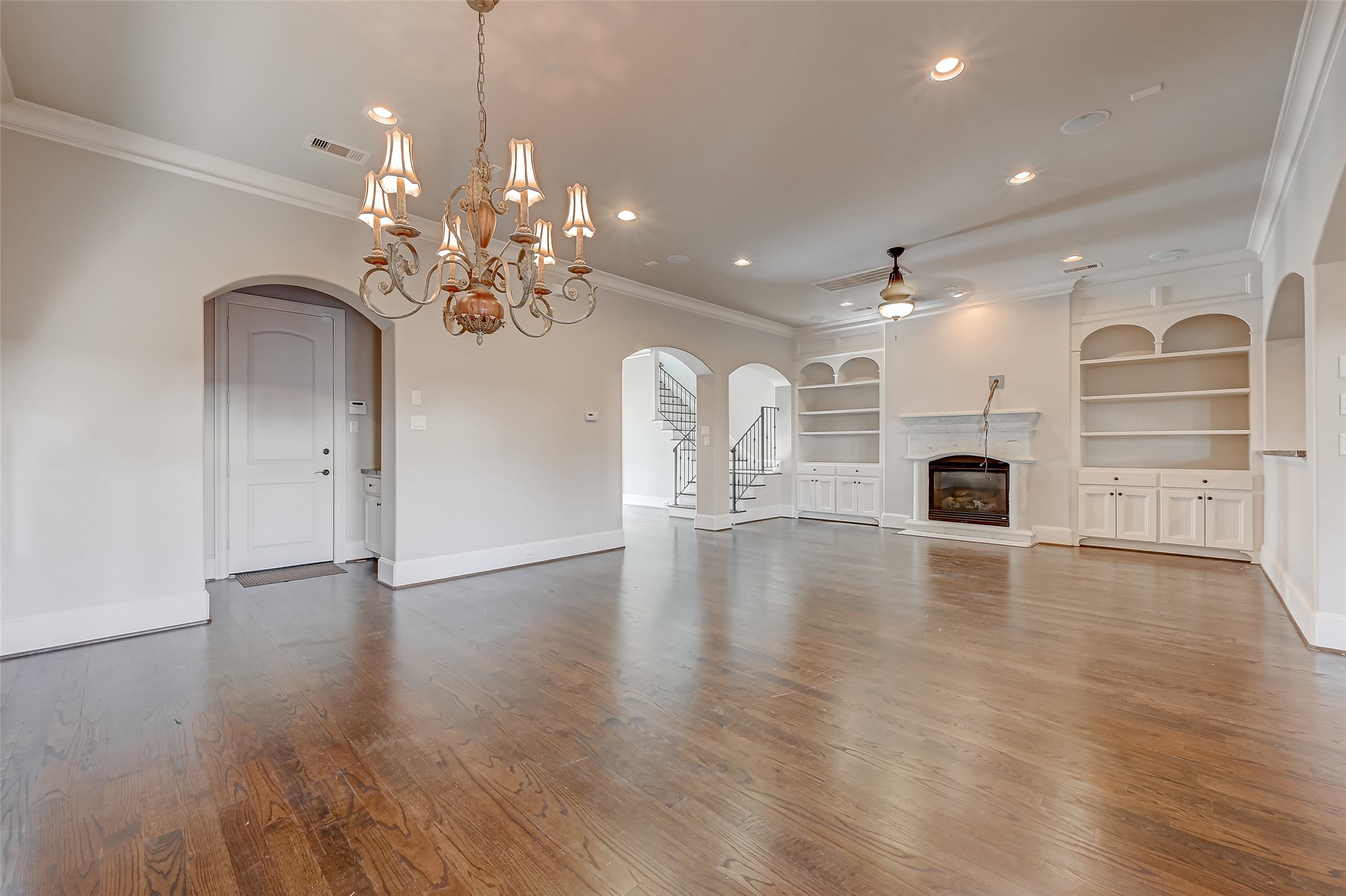 7619 Pine Ridge Terrace Road Houston, TX 77081 - Photo 7 of 32 a view of a livingroom with a fireplace a chandelier and wooden floor