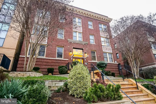 a view of a brick building next to a yard