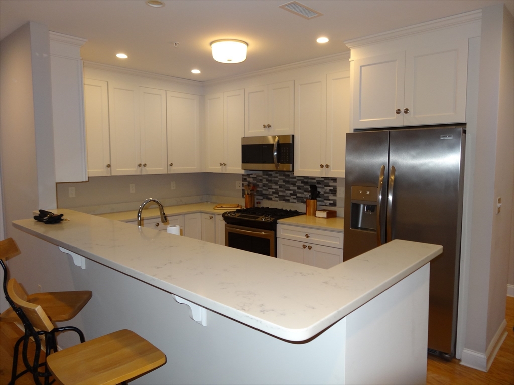 2 Inwood Drive, Unit 1005 Woburn, MA 01801 - Photo 4 of 8 a kitchen that has a sink and a stove in it