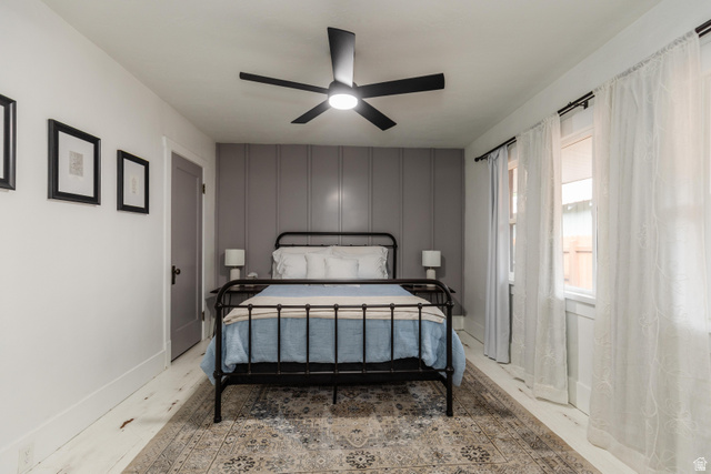 130 North 100 East Logan, UT 84321 - Photo 26 of 35 Light wood-finish flooring, accent wall with vertical paneling, and a contemporary ceiling fan
