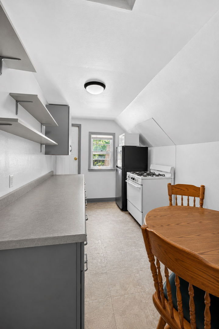 226 West Locust Street DeKalb, IL 60115 - Photo 26 of 40 a kitchen that has a microwave a table and chairs in it