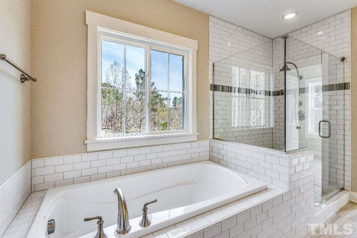 1416 Baileys Run Court Raleigh, NC 27606 - Photo 13 of 21 Garden tub surrounded by subway tile. Oversized and tiled shower with decorative accents.