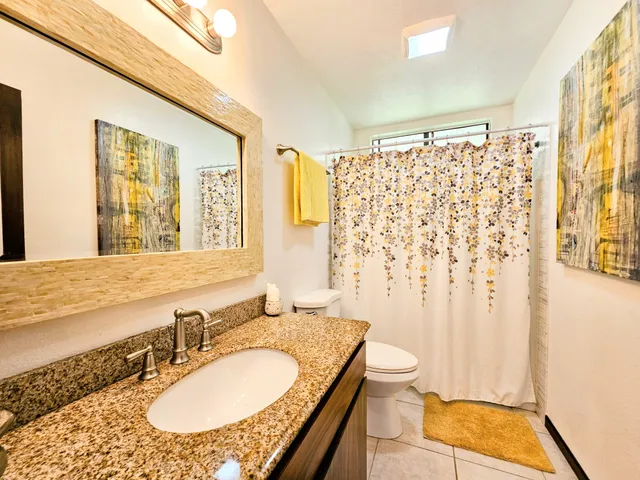 a kitchen with granite countertop wooden cabinets stainless steel appliances a sink and a large window