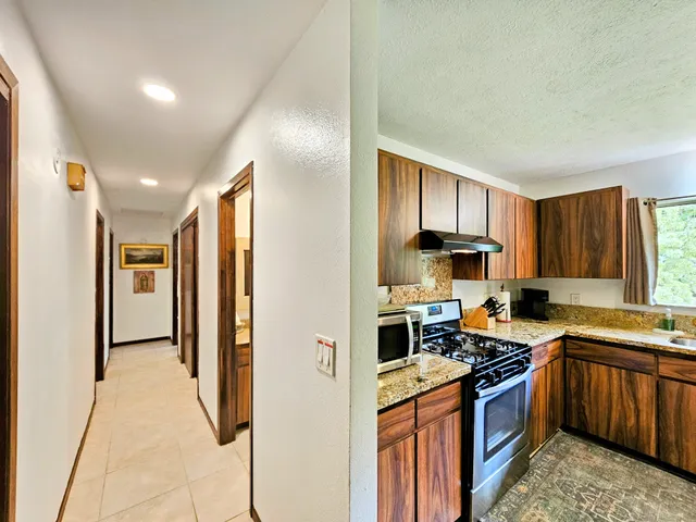 a bathroom with a granite countertop sink a toilet a mirror a vanity and shower