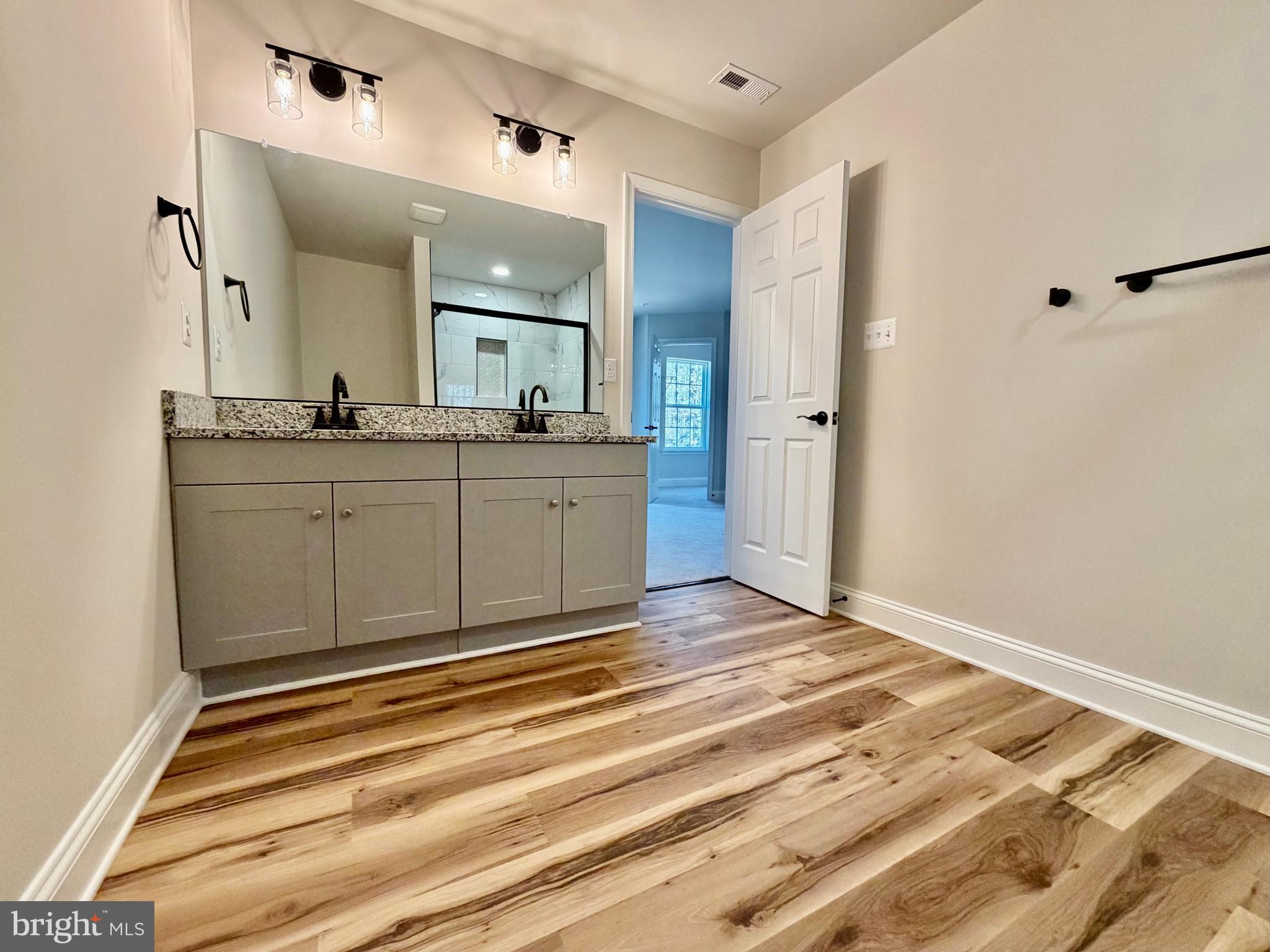 613 Santa Fe Trail Lusby, MD 20657 - Photo 14 of 24 a spacious bathroom with a sink and a mirror