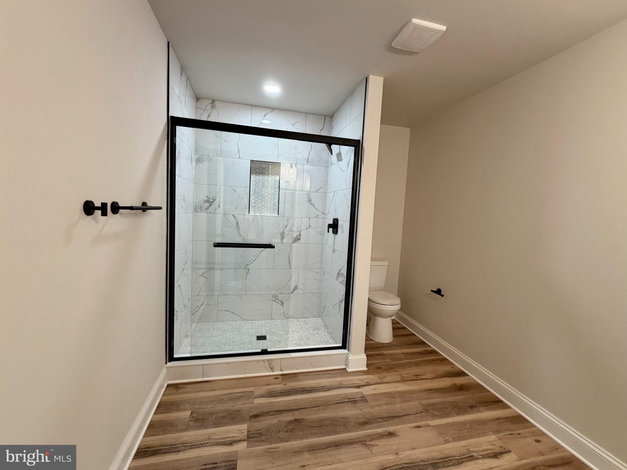 613 Santa Fe Trail Lusby, MD 20657 - Photo 16 of 24 a view of a hallway with wooden floor and a bathroom