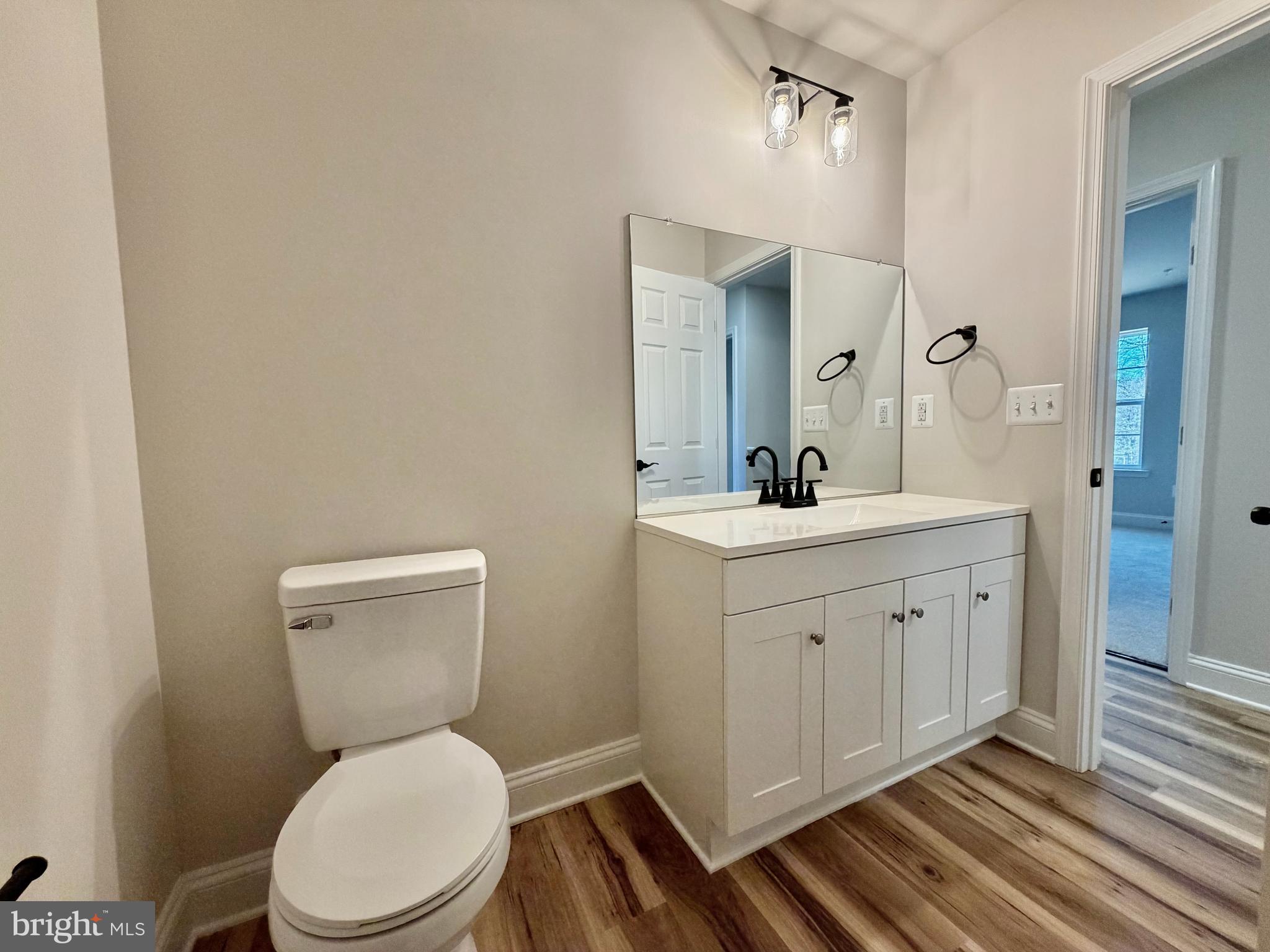 613 Santa Fe Trail Lusby, MD 20657 - Photo 18 of 24 a bathroom with a toilet a sink a mirror and vanity