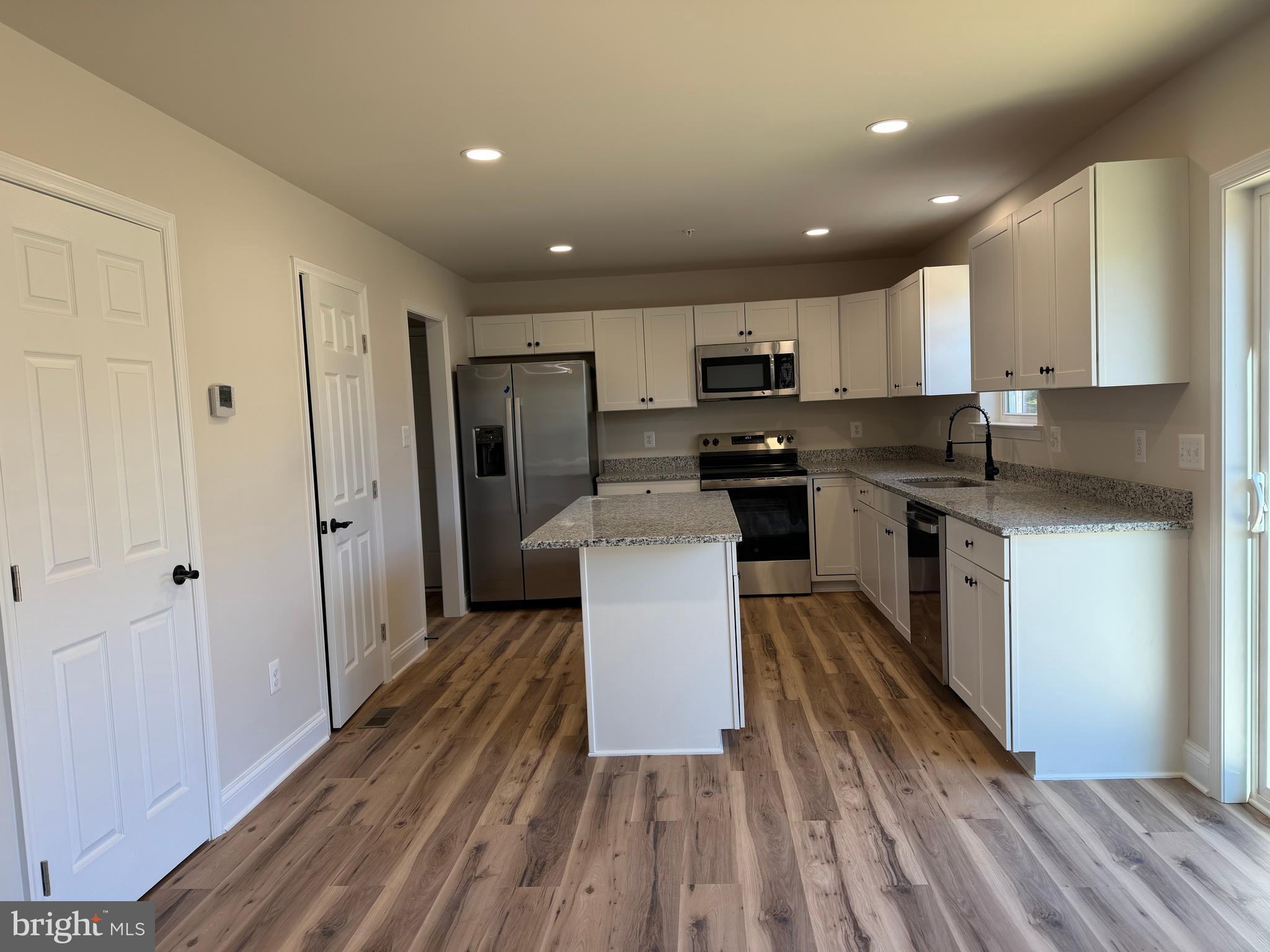613 Santa Fe Trail Lusby, MD 20657 - Photo 5 of 24 a kitchen with kitchen island wooden floors appliances and cabinets