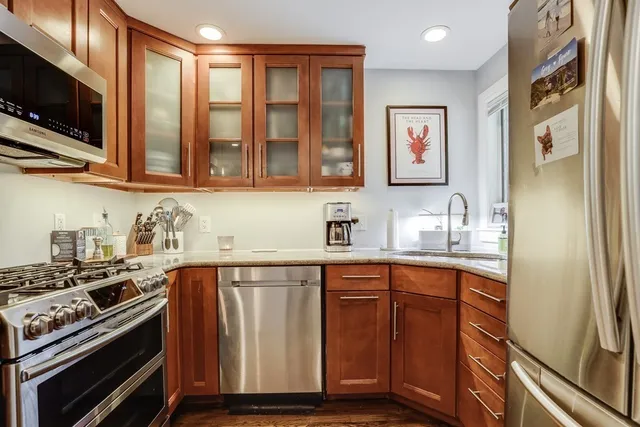 a kitchen with stainless steel appliances granite countertop a stove a sink and a microwave