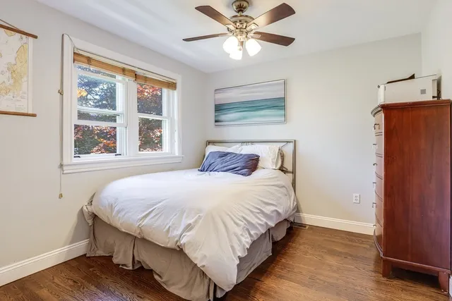 a bedroom with a large bed chandelier and a window