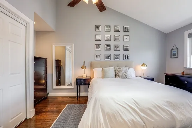 a bedroom with a bed and a lamp on dresser