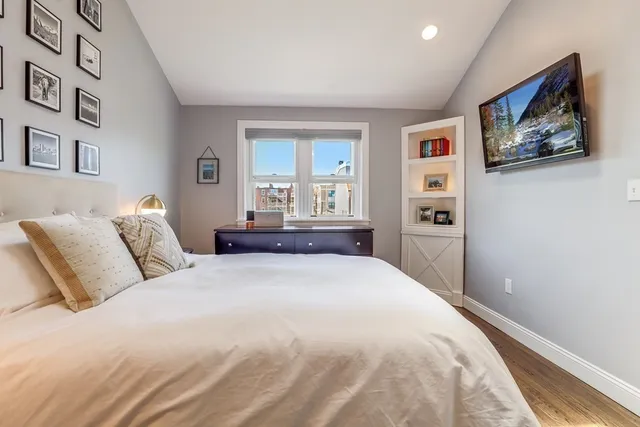 a bedroom with a large bed and a painting on the wall