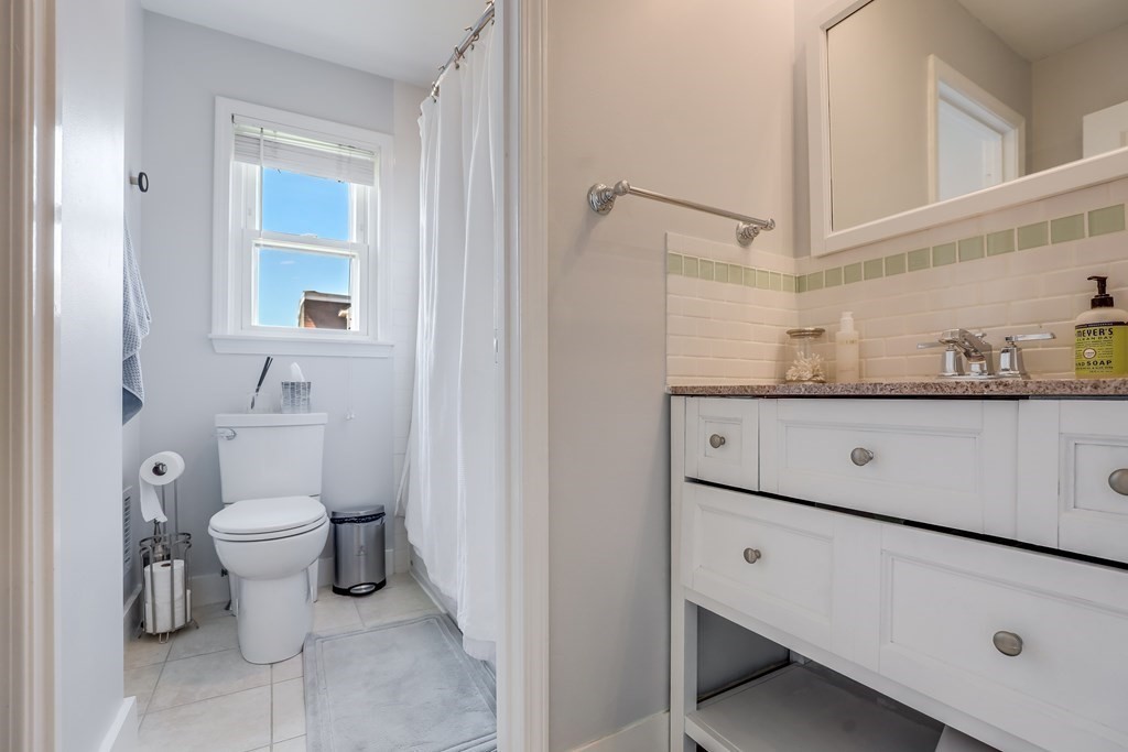 154 West 3rd Street, Unit 154 Boston, MA 02127 - Photo 19 of 26 a bathroom with a granite countertop toilet sink and mirror