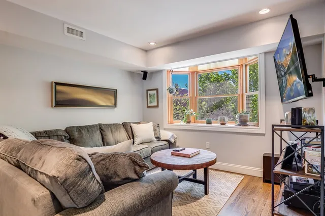 a living room with furniture a flat screen tv and a large window