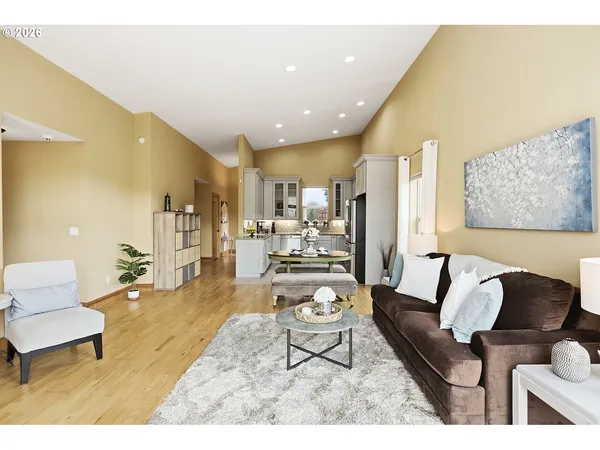 a bedroom with a bed wooden floor and a large window