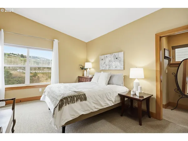 a bedroom with a bed and a large window