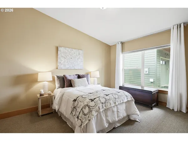 a bedroom with a bed and a large window