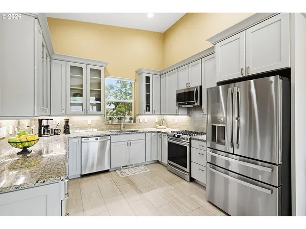 a kitchen with granite countertop a refrigerator stove top oven and sink