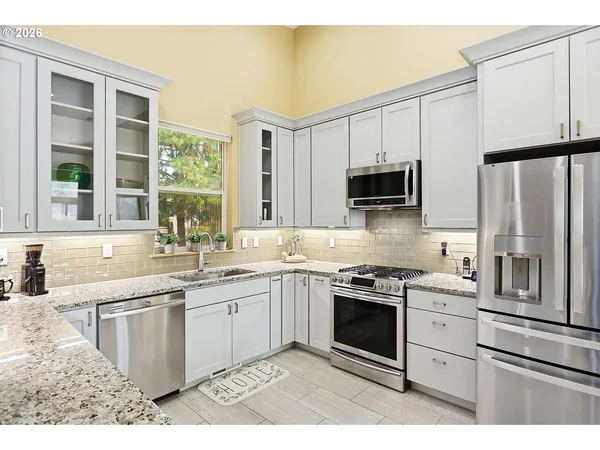 a kitchen with stainless steel appliances granite countertop a stove a sink and a refrigerator
