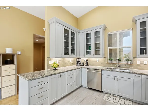 a kitchen with a refrigerator a stove a sink dishwasher with a dining table and chairs