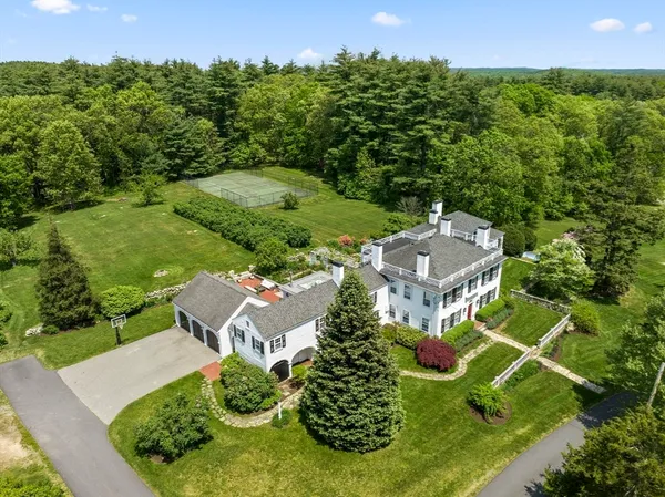 an aerial view of residential house with outdoor space and trees all around
