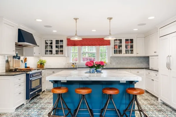 a kitchen with stainless steel appliances granite countertop a stove top oven a sink dishwasher and white cabinets with wooden floor