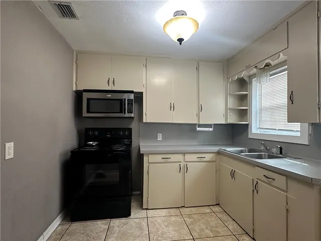 a kitchen with a sink and a stove top oven