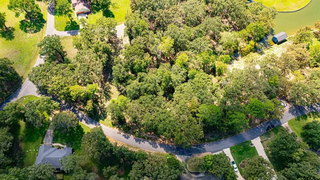 an aerial view of residential house with outdoor space and trees all around