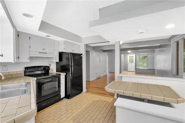 a kitchen with kitchen island sink stove and refrigerator