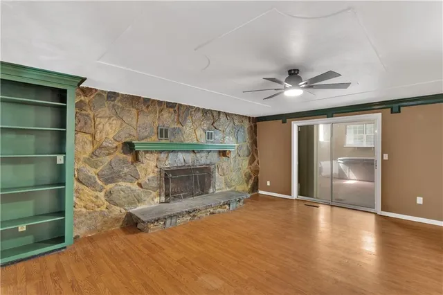 a view of an empty room with a fireplace and a window