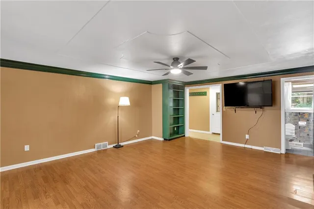a view of a livingroom with wooden floor and windows