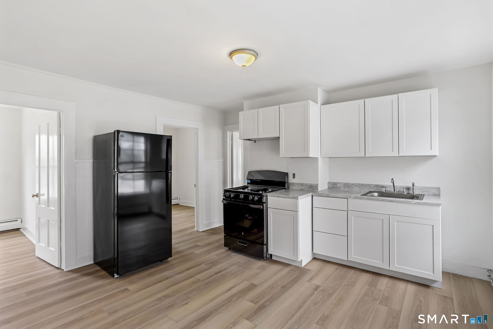 63 Reynolds Street, Unit B Killingly, CT 06239 - Photo 22 of 32 a kitchen with a refrigerator and a stove top oven