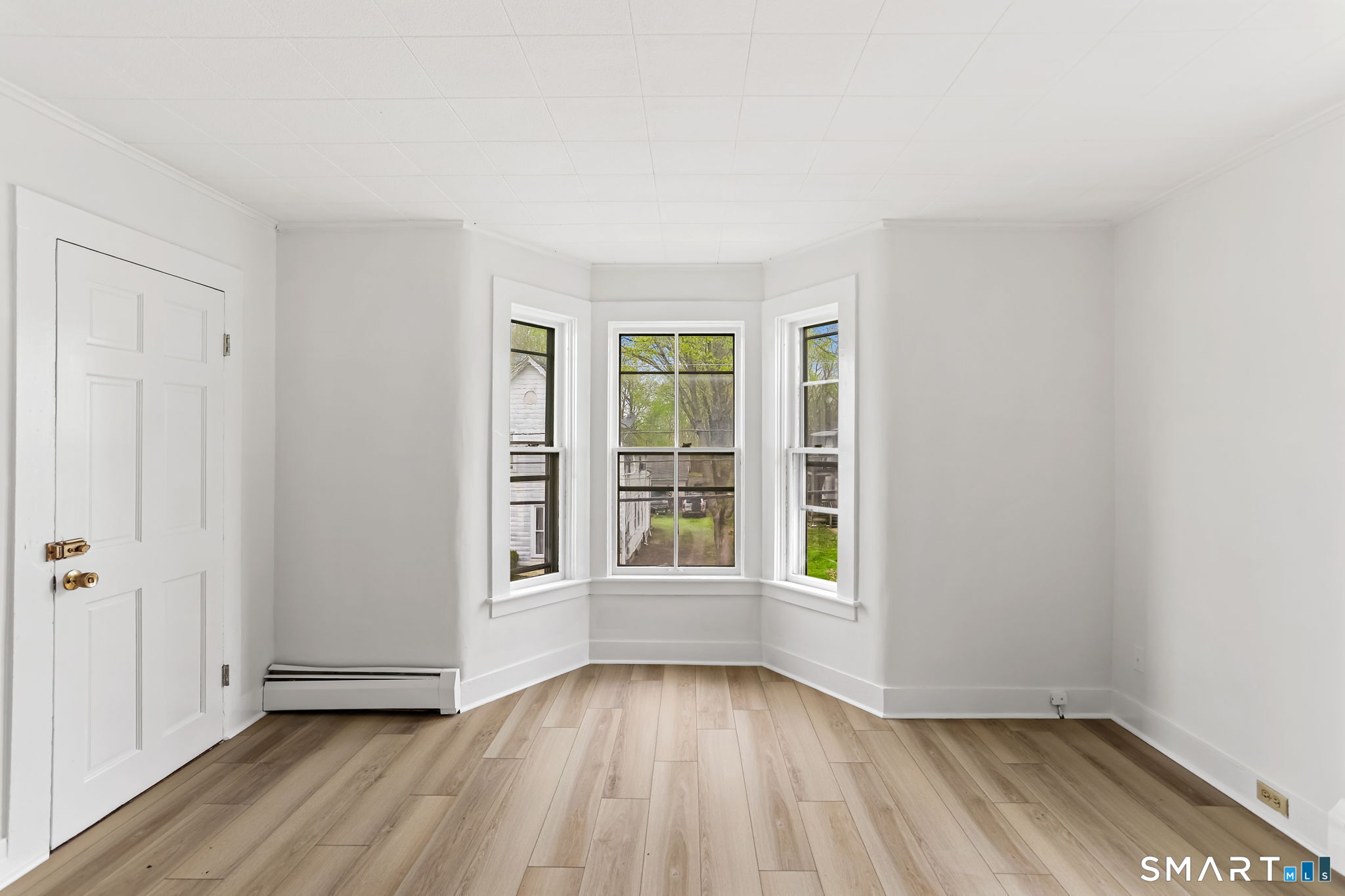 63 Reynolds Street, Unit B Killingly, CT 06239 - Photo 25 of 32 an empty room with wooden floor and windows