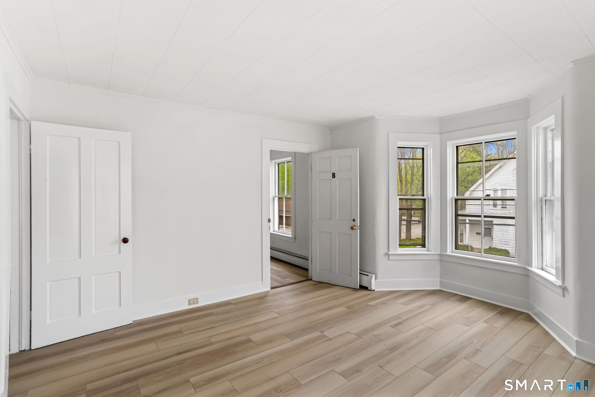 63 Reynolds Street, Unit B Killingly, CT 06239 - Photo 27 of 32 an empty room with wooden floor and windows