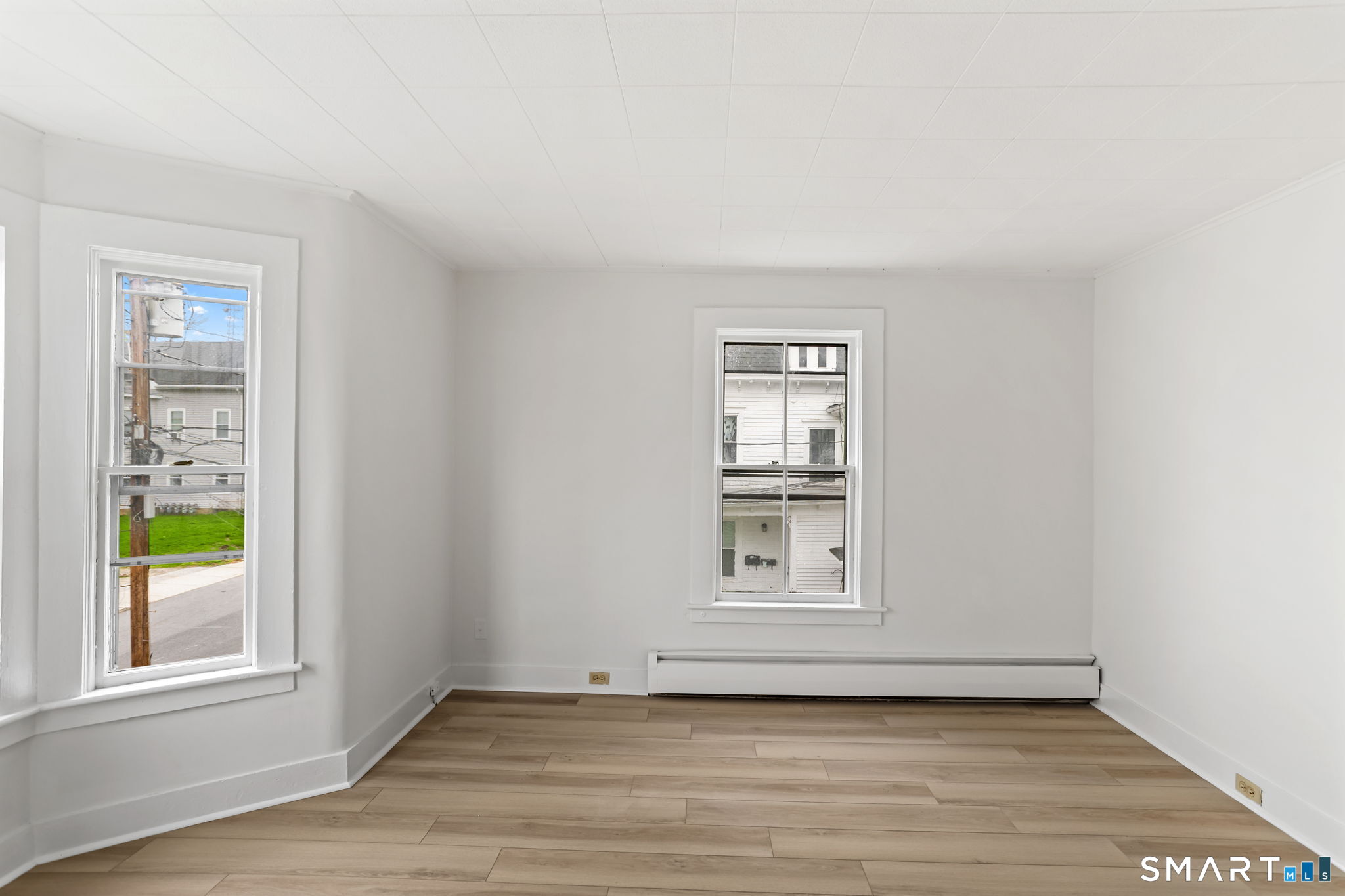 63 Reynolds Street, Unit B Killingly, CT 06239 - Photo 29 of 32 an empty room with wooden floor and windows