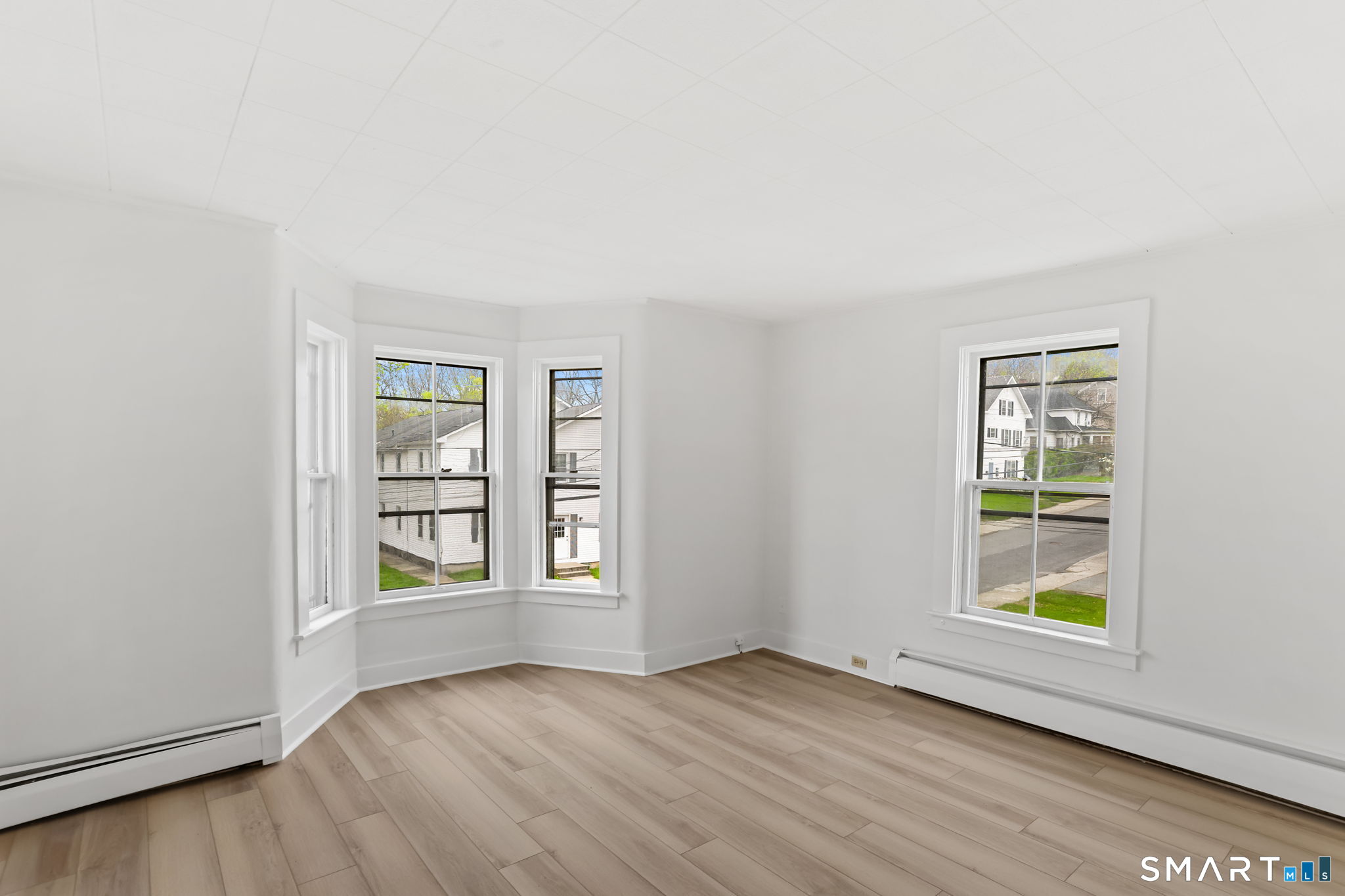 63 Reynolds Street, Unit B Killingly, CT 06239 - Photo 30 of 32 an empty room with wooden floor and windows