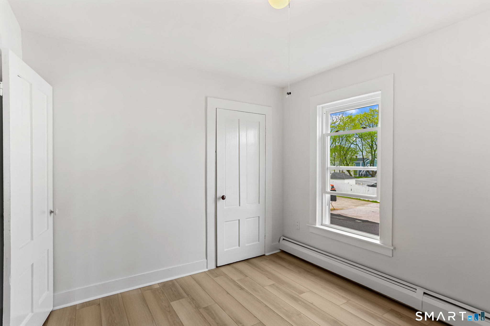 63 Reynolds Street, Unit B Killingly, CT 06239 - Photo 6 of 32 a view of an empty room with wooden floor and a window