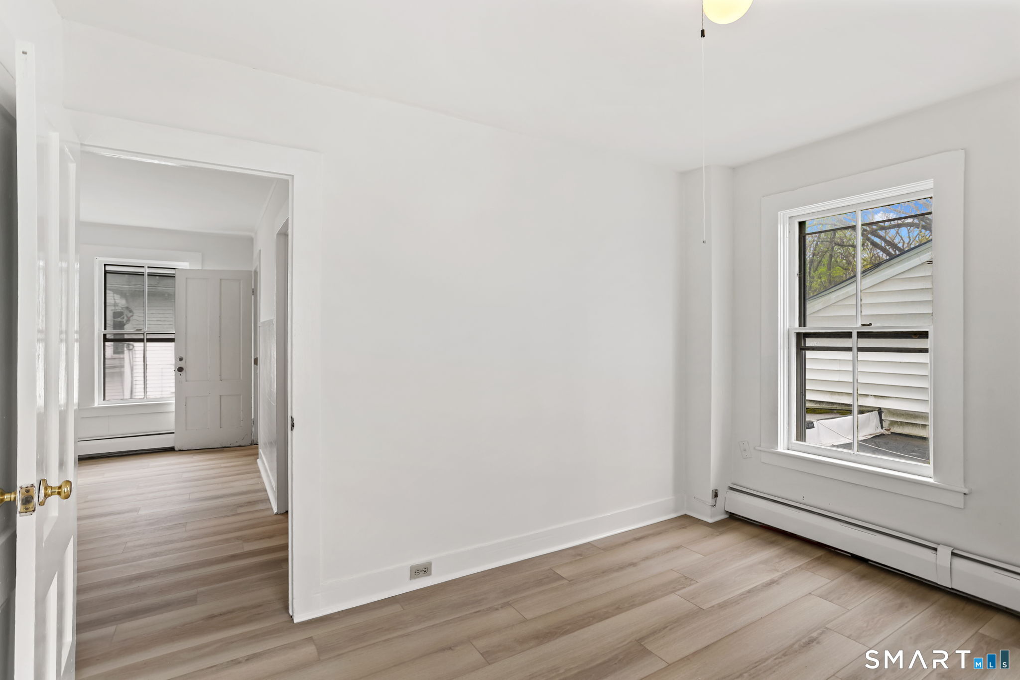 63 Reynolds Street, Unit B Killingly, CT 06239 - Photo 9 of 32 a view of an empty room with wooden floor and a window