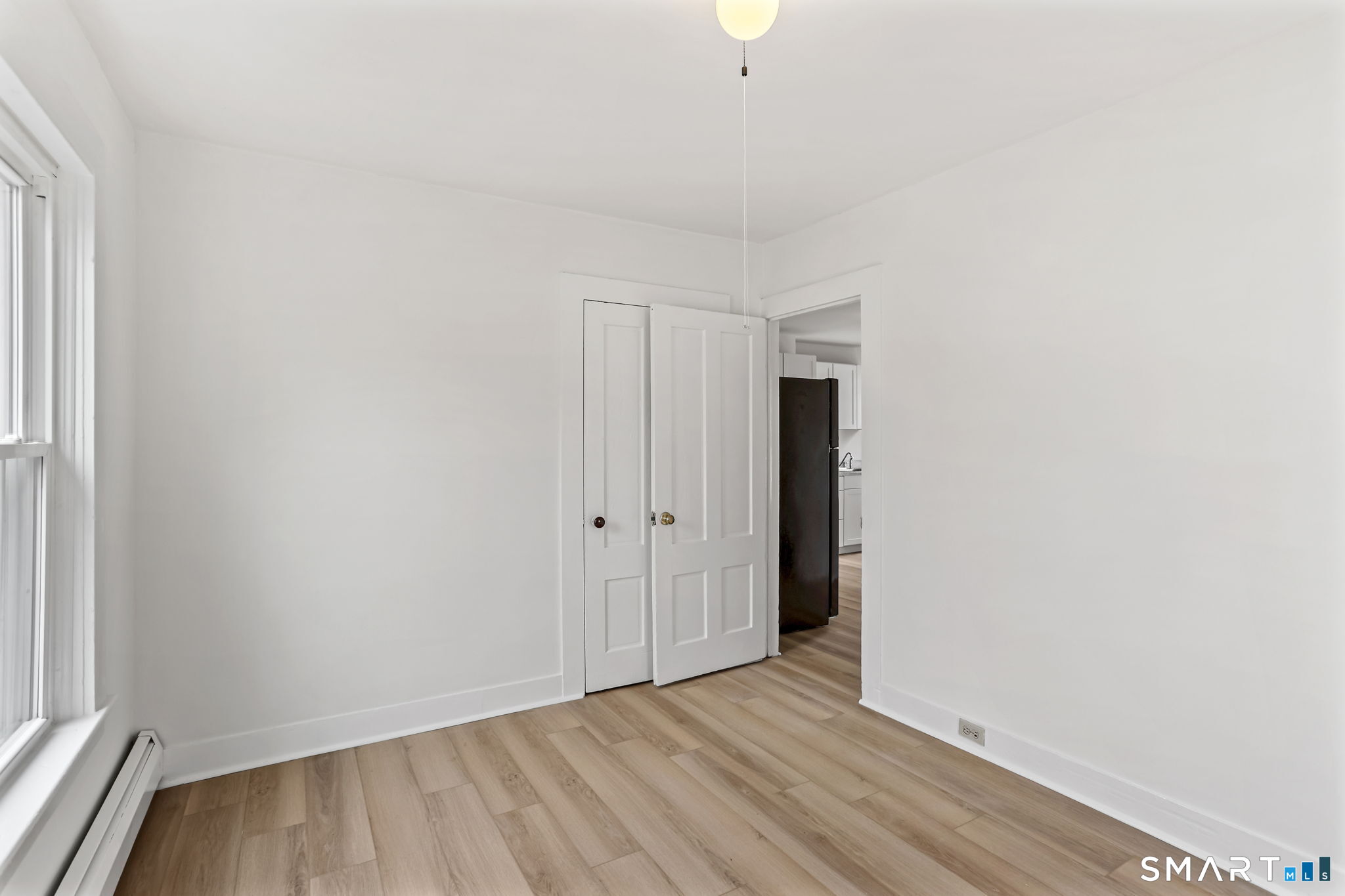 63 Reynolds Street, Unit B Killingly, CT 06239 - Photo 10 of 32 a view of an empty room with wooden floor and a window