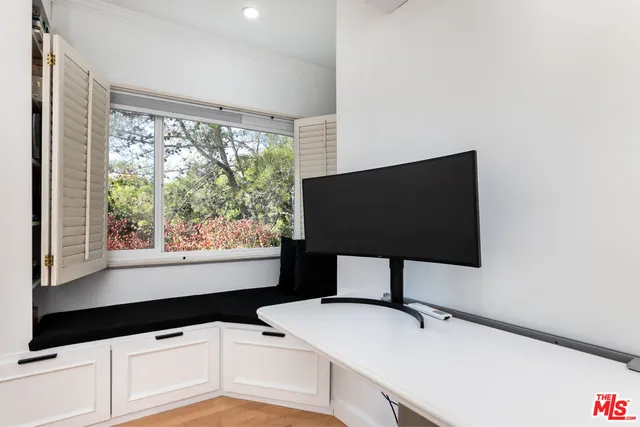a room with a large window and ceiling fan