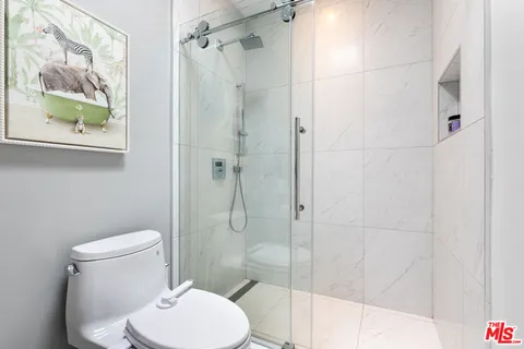 a white toilet sitting next to a bathroom shower