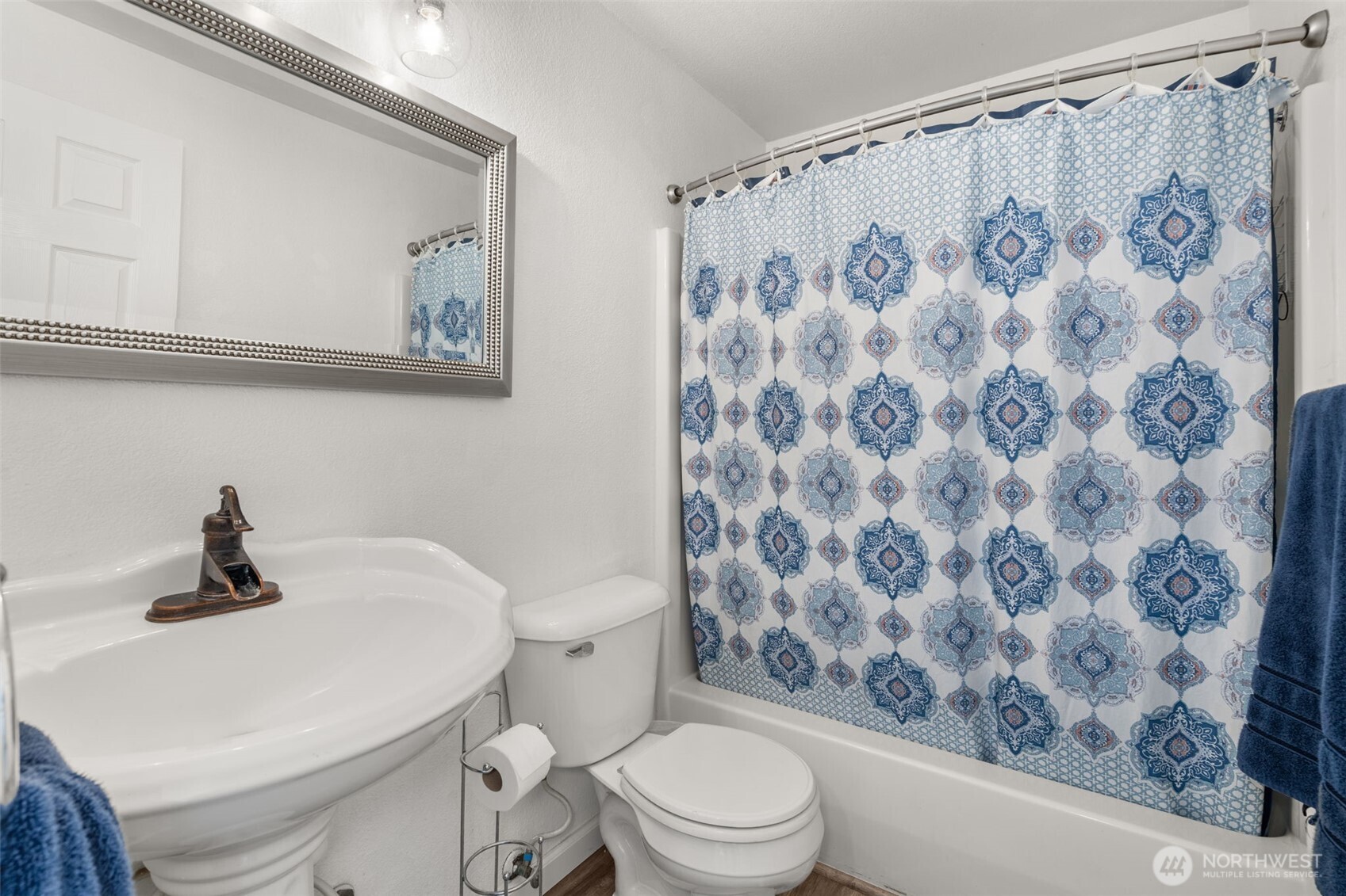 5916 187th Lane Southwest Rochester, WA 98579 - Photo 16 of 39 a white toilet sitting next to a shower curtain