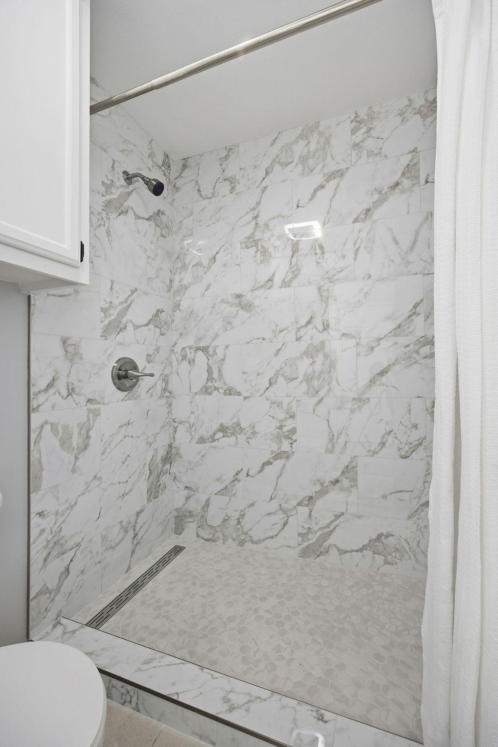 6486 Hart Lane Austin, TX 78731 - Photo 15 of 28 Full bath with a marble finish shower and toilet