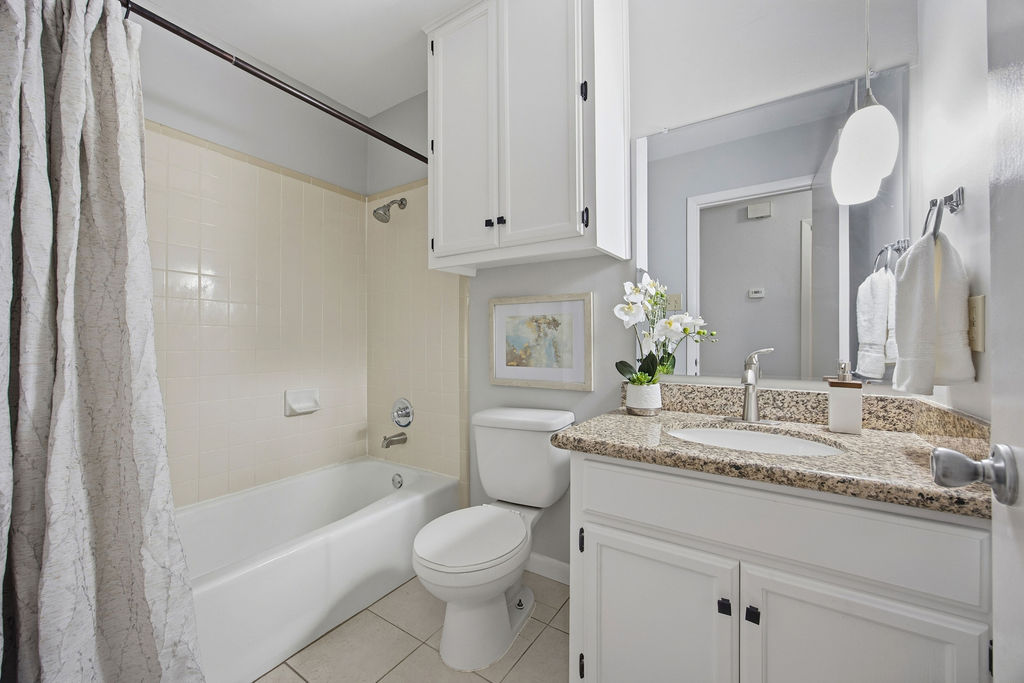 6486 Hart Lane Austin, TX 78731 - Photo 16 of 28 Full bath featuring shower / bath combo, vanity, and light tile patterned floors