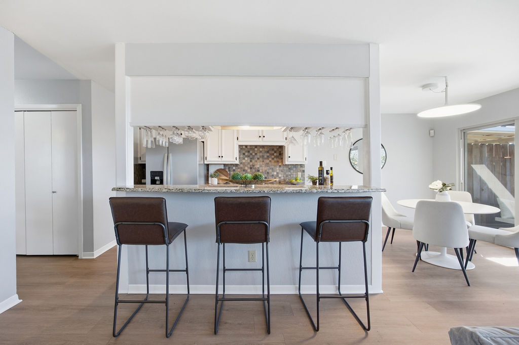 6486 Hart Lane Austin, TX 78731 - Photo 5 of 28 Kitchen featuring light wood-type flooring, white cabinetry, and light stone counters