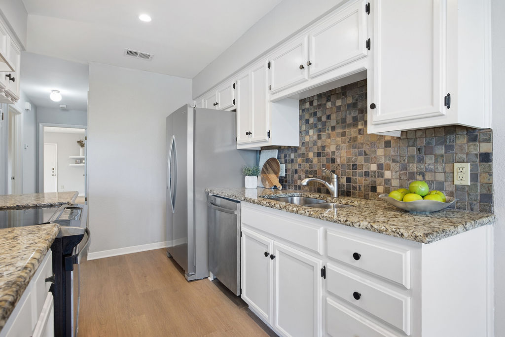 6486 Hart Lane Austin, TX 78731 - Photo 10 of 28 Kitchen featuring stainless steel appliances, white cabinets, light stone countertops, light wood-style floors, and recessed lighting