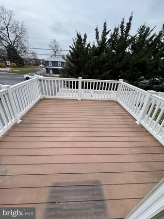a view of deck space with swimming pool and trees