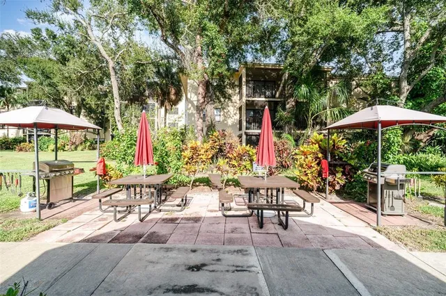 a view of a chairs and table under an umbrella in backyard
