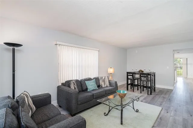 a living room with furniture wooden floor and a window